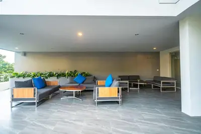 a lobby with couches and tables and blue pillows at Ark Studio only 10 Minutes from kataKaron Beach in Karon Beach
