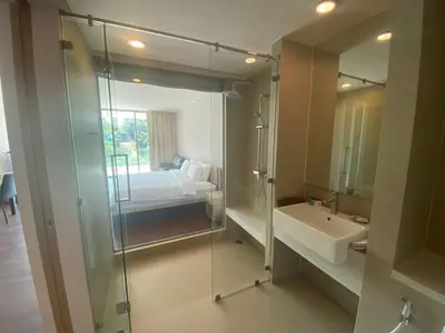 a bathroom with a glass shower and a sink at Ark Studio only 10 Minutes from kataKaron Beach in Karon Beach