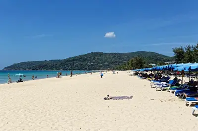 a beach with a bunch of chairs and umbrellas at Ark Studio only 10 Minutes from kataKaron Beach in Karon Beach