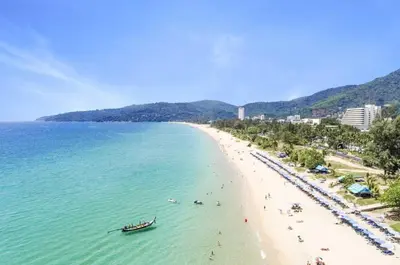a beach with people and a boat in the water at Ark Studio only 10 Minutes from kataKaron Beach in Karon Beach