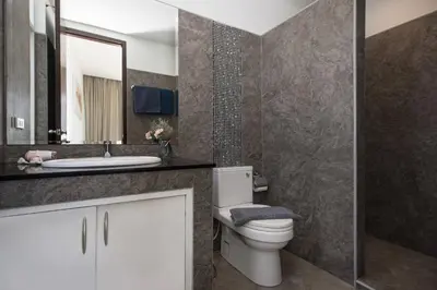 a bathroom with a toilet and a sink and a mirror at Relaxing Holidays - 2BR Private Pool Villa Greens 8, Rawai in Rawai Beach
