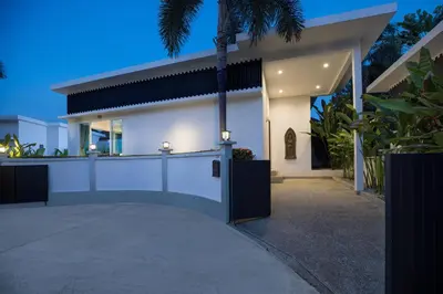a white house with a gate in front of it at Relaxing Holidays - 2BR Private Pool Villa Greens 8, Rawai in Rawai Beach