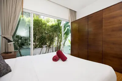a bedroom with a white bed with a large window at Relaxing Holidays - 2BR Private Pool Villa Greens 8, Rawai in Rawai Beach