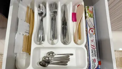 a white sink with silver utensils in a drawer at Cozy family townhouse in Chalong