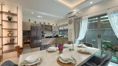 a kitchen and dining room with a table and chairs at Cozy family townhouse in Chalong