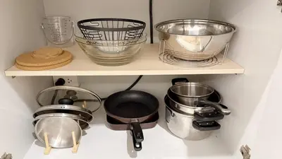 a shelf with pots and pans and other kitchen utensils at Cozy family townhouse in Chalong