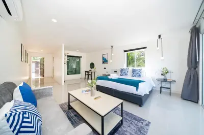 a bedroom and living room with a bed and a couch at Patong Cliff Pool villa in Patong Beach