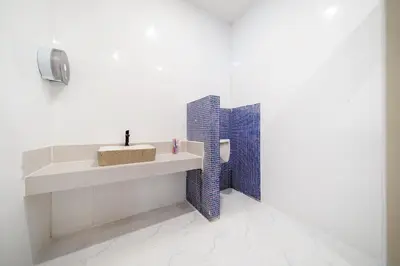 a white bathroom with a sink and blue tiles at Patong Cliff Pool villa in Patong Beach