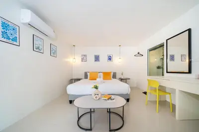 a bedroom with a bed and a desk and a table at Patong Cliff Pool villa in Patong Beach
