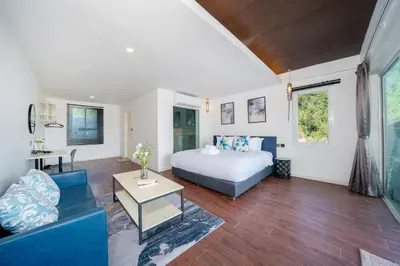 a bedroom with a bed and a living room at Patong Cliff Pool villa in Patong Beach