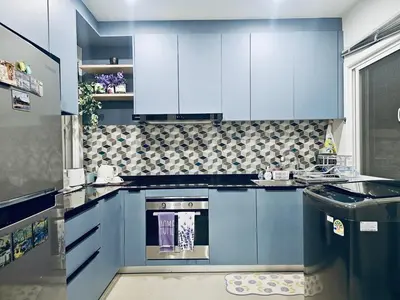 a kitchen with blue cabinets and a stove at Sirihouse at Supalai Bella Thalang Phuket in Phuket