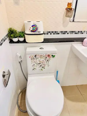 a bathroom with a white toilet with flowers on it at Sirihouse at Supalai Bella Thalang Phuket in Phuket