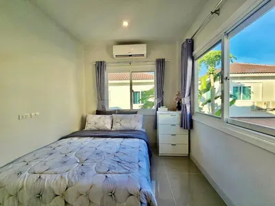 a small bedroom with a bed and a window at Sirihouse at Supalai Bella Thalang Phuket in Phuket