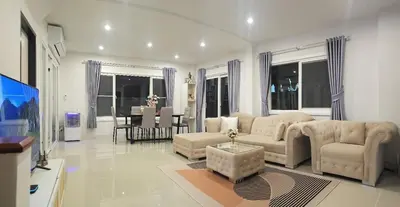a living room with a couch and a dining room at Sirihouse at Supalai Bella Thalang Phuket in Phuket