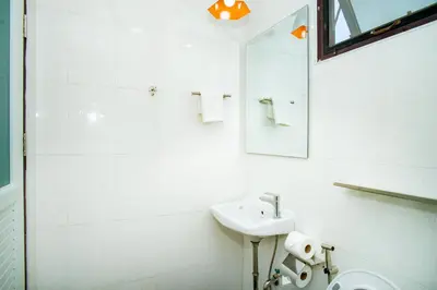 a white bathroom with a sink and a mirror at Songbird Suites - Deluxe 2 Bedroom, 2 Bathroom Apt in Ban Khlong Haeng