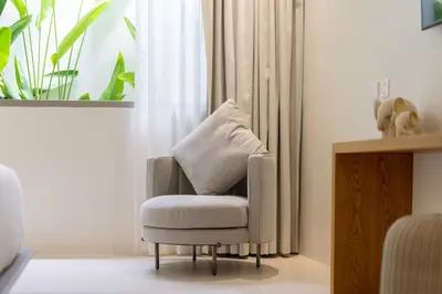 a chair with a pillow in a living room at Coco Villas Phuket - Private Pool Villas by Escape Villas in Thalang