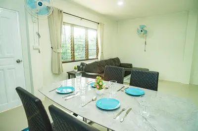 a dining room table with blue plates and chairs at Songbird Suites - Deluxe King Suite and Scooter in Ao Nang Beach