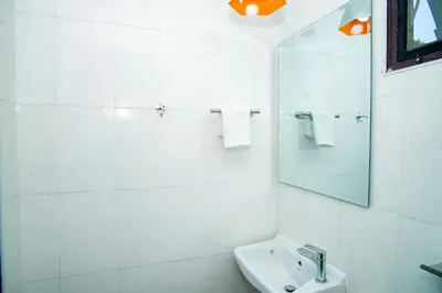 a white bathroom with a sink and a mirror at Songbird Suites - Deluxe King Suite and Scooter in Ao Nang Beach