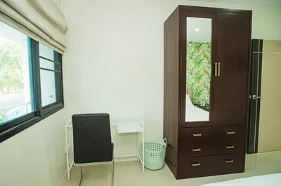 a room with a cabinet and a desk with a mirror at Songbird Suites - Deluxe King Suite and Scooter in Ao Nang Beach