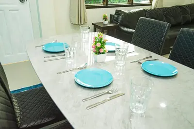 a table with blue plates and glasses on it at Songbird Suites - Deluxe King Suite and Scooter in Ao Nang Beach