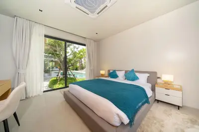 a bedroom with a large bed and a large window at Bang Tao Botanica Modern Loft 3 bd in Ban Pak Lak