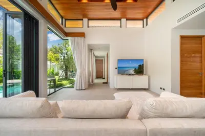 a living room with a couch and a tv at Bang Tao Botanica Modern Loft 3 bd in Ban Pak Lak