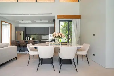 a kitchen and dining room with a table and chairs at Bang Tao Botanica Modern Loft 3 bd in Ban Pak Lak