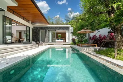 an infinity pool in a villa with a house at Bang Tao Botanica Modern Loft 4 bd S in Phuket