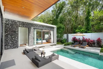 a patio with a swimming pool and a house at Bang Tao Botanica Modern Loft 4 bd S in Phuket