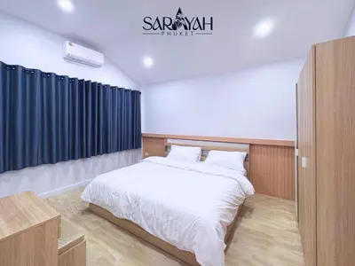a bedroom with a large white bed with blue curtains at Sarayah Phuket 4Bed Villa in Ban Tha Rua