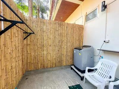 a screened in porch with a white chair next to a fence at Oasis 1 Bedroom Apartment In Rawai in Phuket Town