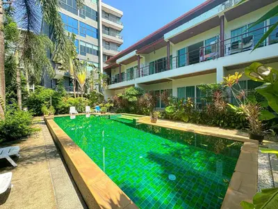 a swimming pool in front of a building at Oasis 1 Bedroom Apartment In Rawai in Phuket Town