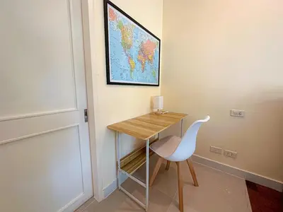a desk with a white chair and a map on the wall at Oasis 1 Bedroom Apartment In Rawai in Phuket Town