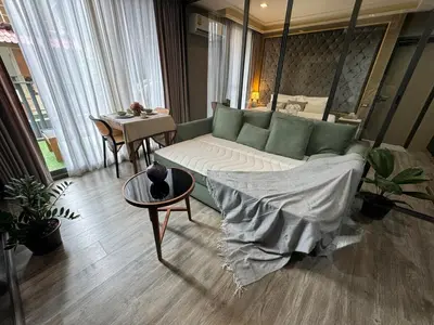 a living room with a couch and a table at Patong rooftop Pool luxury Condo with Bathtub and sofa bed big balcony in Patong Beach
