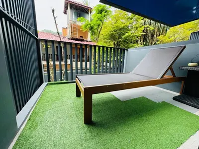 a porch with a hammock on a balcony with green grass at Patong rooftop Pool luxury Condo with Bathtub and sofa bed big balcony in Patong Beach