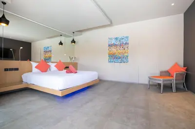 a bedroom with a bed and a table and a chair at Luxurious 5BR Villa Mayacol with 17m Long Pool, NaiHarn in Rawai Beach