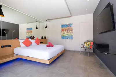 a bedroom with a white bed with red pillows at Luxurious 5BR Villa Mayacol with 17m Long Pool, NaiHarn in Rawai Beach