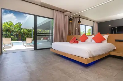 a bedroom with a bed with red pillows at Luxurious 5BR Villa Mayacol with 17m Long Pool, NaiHarn in Rawai Beach