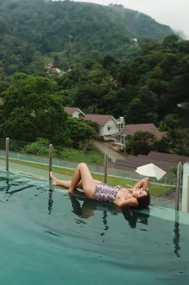 a woman laying on a pole in a swimming pool at Palmetto Park Residence in Karon Beach