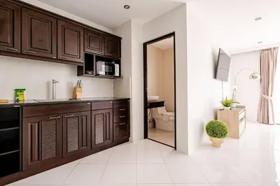 a kitchen with dark wood cabinets and a bathroom at Sunny Stay A8 Charming Residence Close to Nature in Kamala Beach