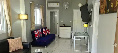a living room with a blue couch and a tv at Karon Homes in Karon Beach