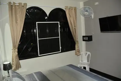 a room with a bed and a window with curtains at Karon Homes in Karon Beach