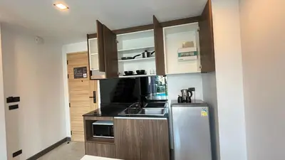 a kitchen with wooden cabinets and a stainless steel refrigerator at Condo Loft style pool access 001 in Rawai Beach