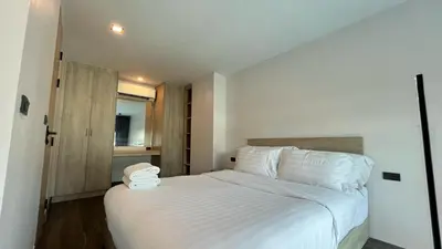a bedroom with a bed with white sheets and pillows at Condo Loft style pool access 001 in Rawai Beach