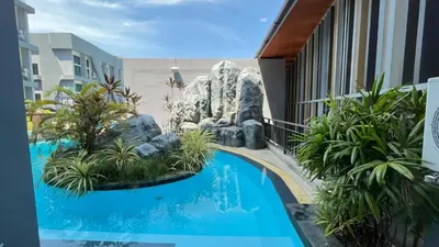 a swimming pool with a rock garden on a building at Condo Loft style pool access 001 in Rawai Beach