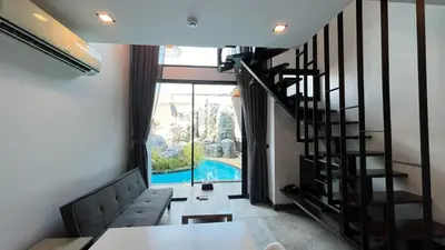 a living room with a staircase and a swimming pool at Condo Loft style pool access 001 in Rawai Beach