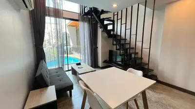 a living room with a white table and a staircase at Condo Loft style pool access 001 in Rawai Beach