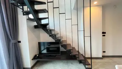 a staircase in a living room with a tv at Condo Loft style pool access 001 in Rawai Beach