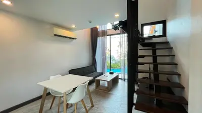 a small dining room with a table and a staircase at Condo Loft style pool access 001 in Rawai Beach
