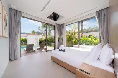a bedroom with a large bed and a large window at Himmapana Villas - Grand Valley in Kamala Beach